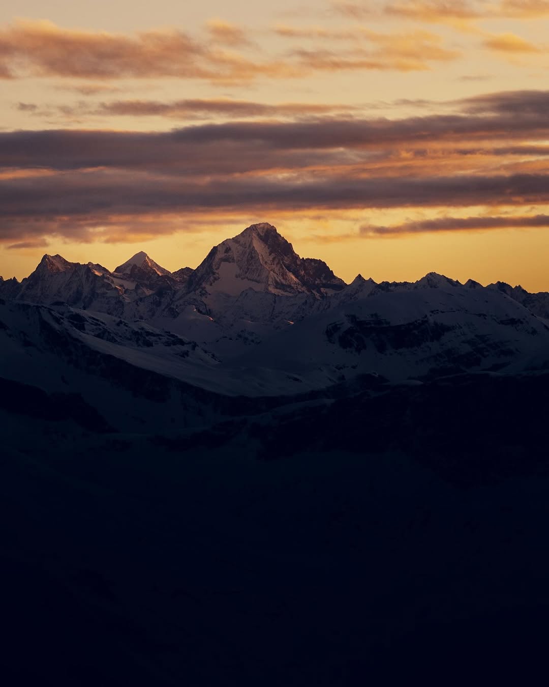 Alpine peaks at first light above the cloud line